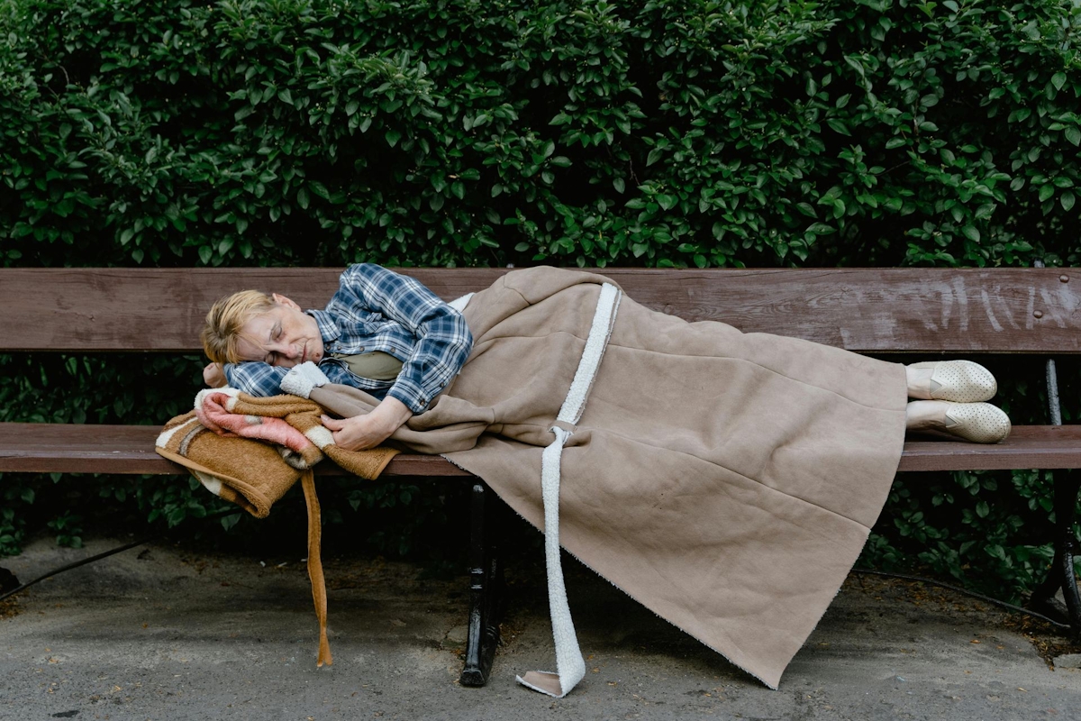 Woman Sleeping on a Wooden Bench