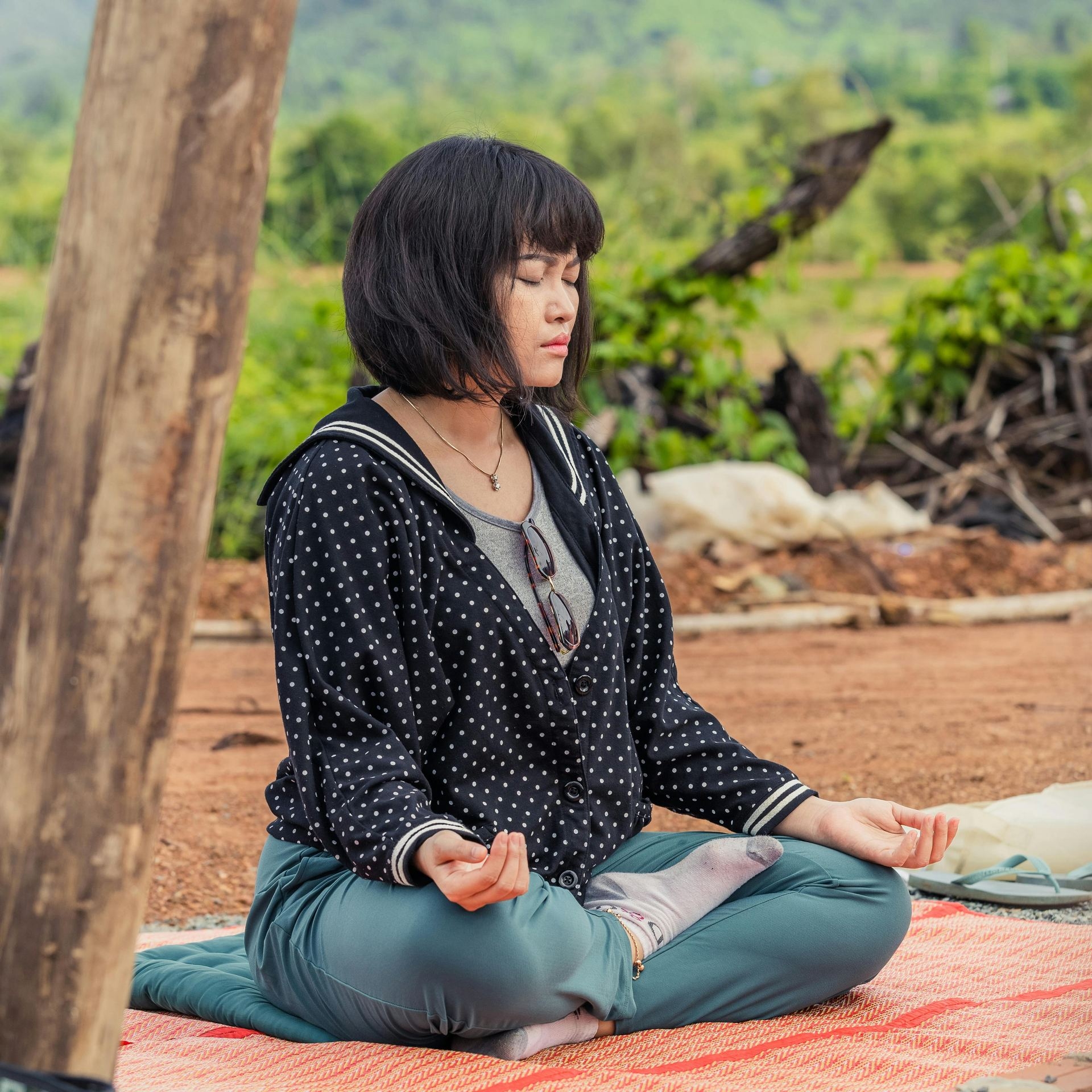 Woman Sitting Outside with Eyes Closed and Meditating 