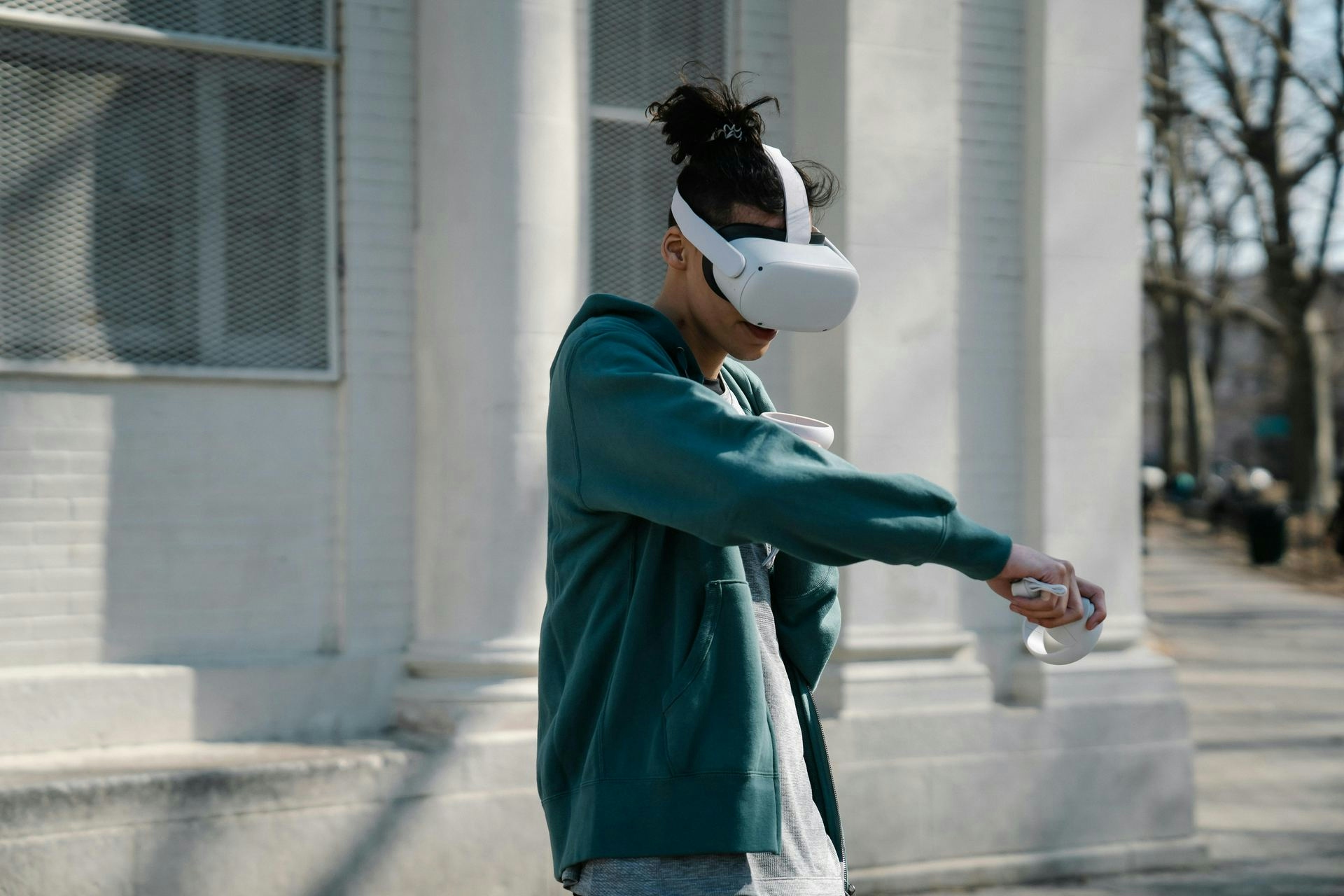 Man with long hair using VR headset and controllers