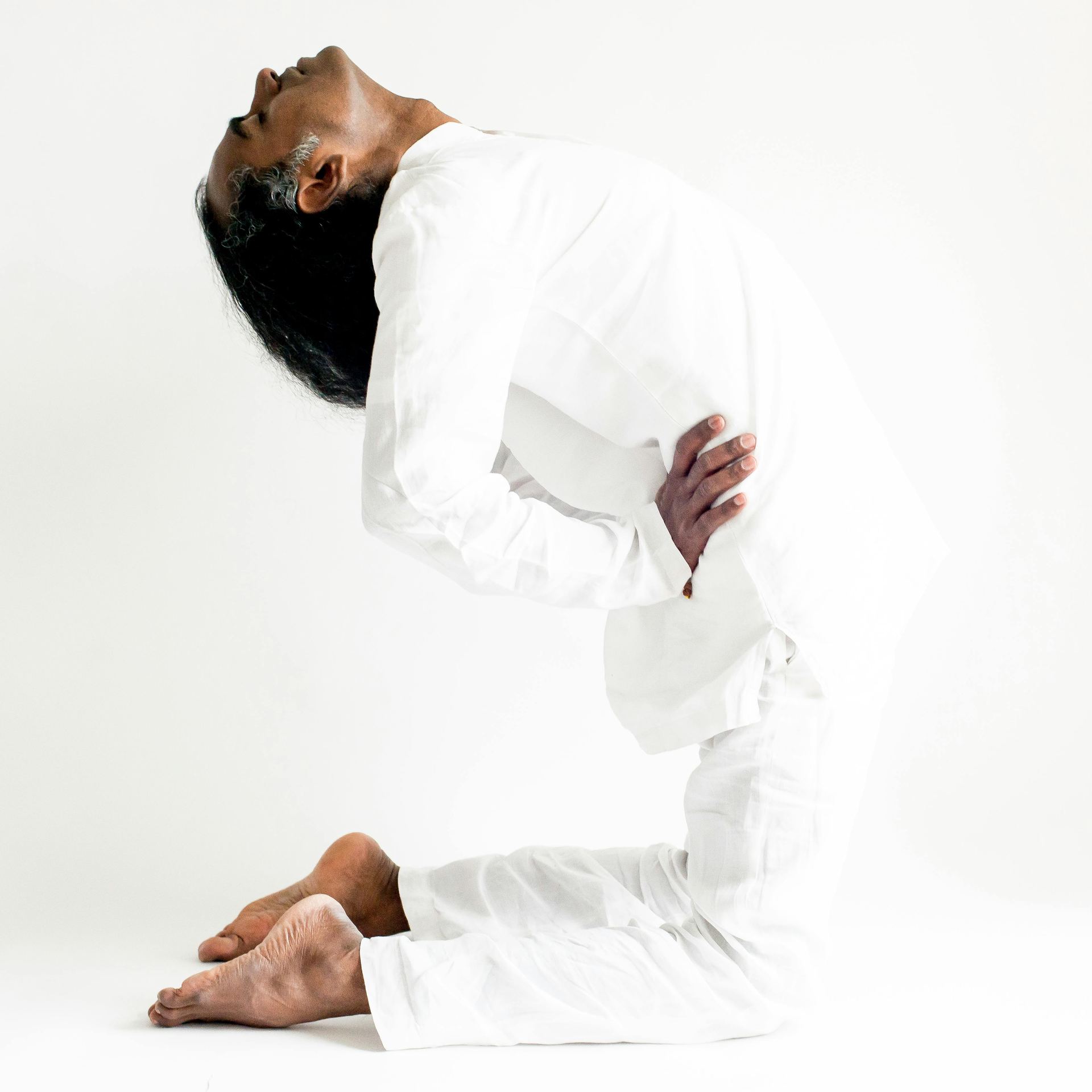 A Man in White Long Sleeves Doing Yoga