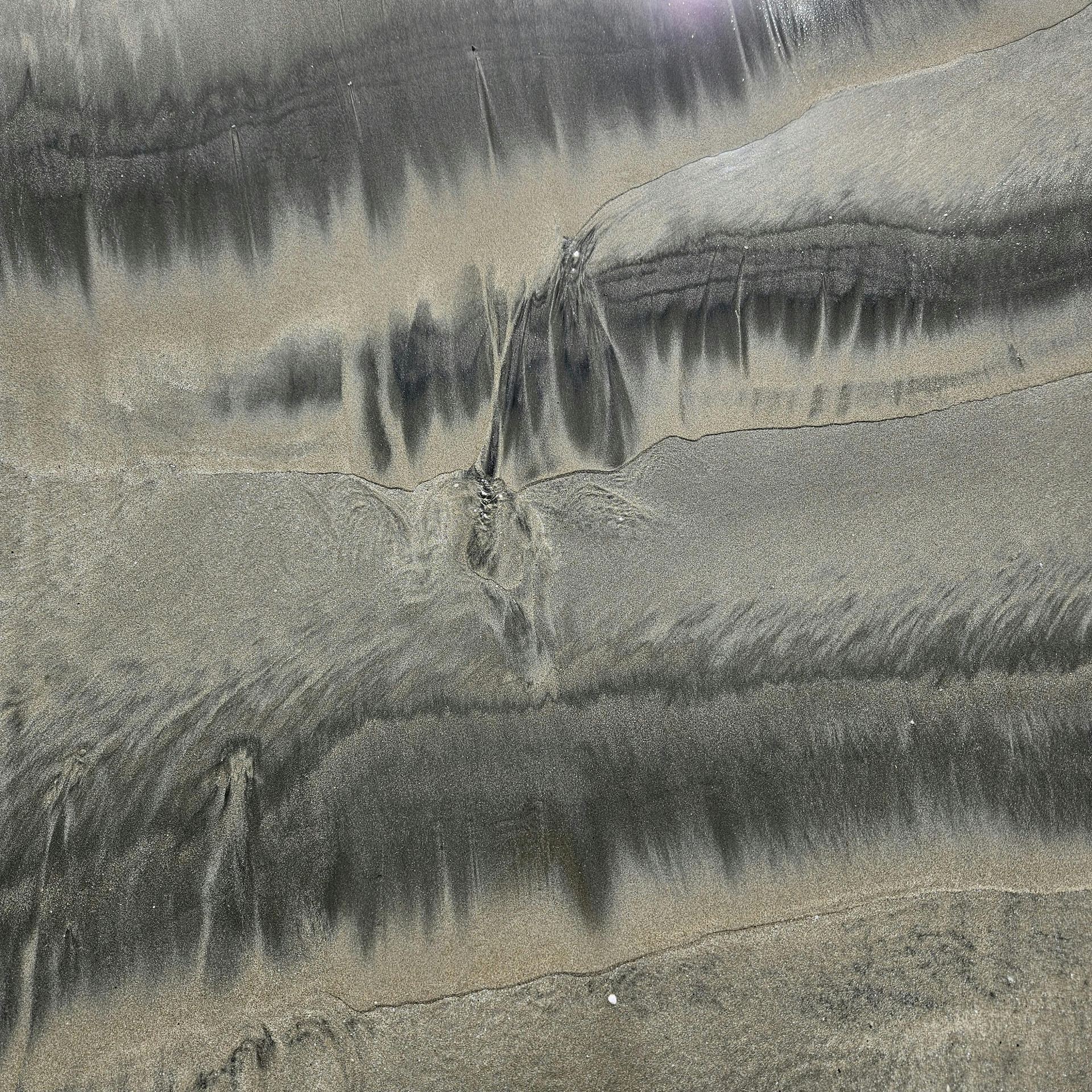 Abstract sand formations on a beach with natural patterns and texture.
