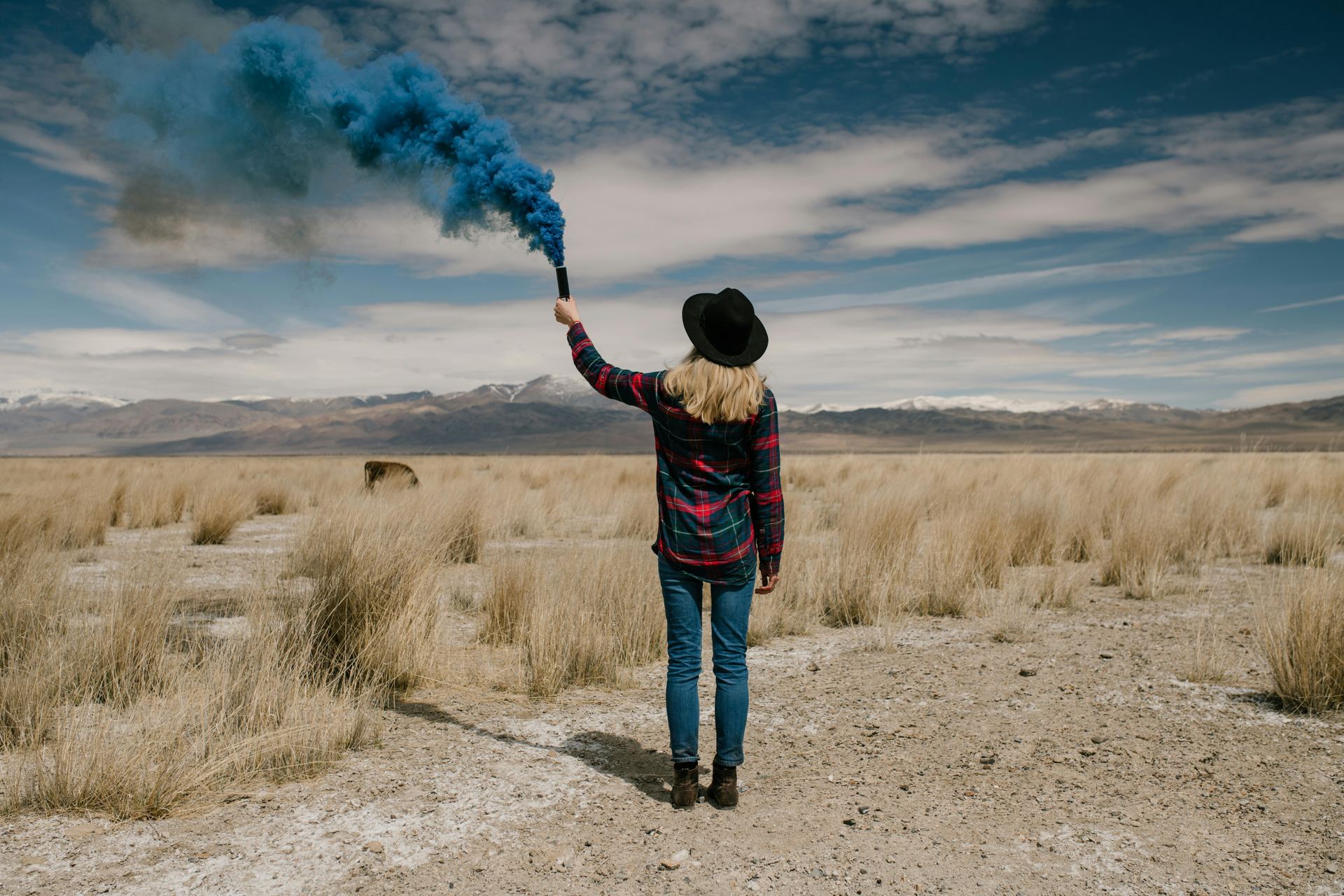 Young woman with colored smoke in desert
