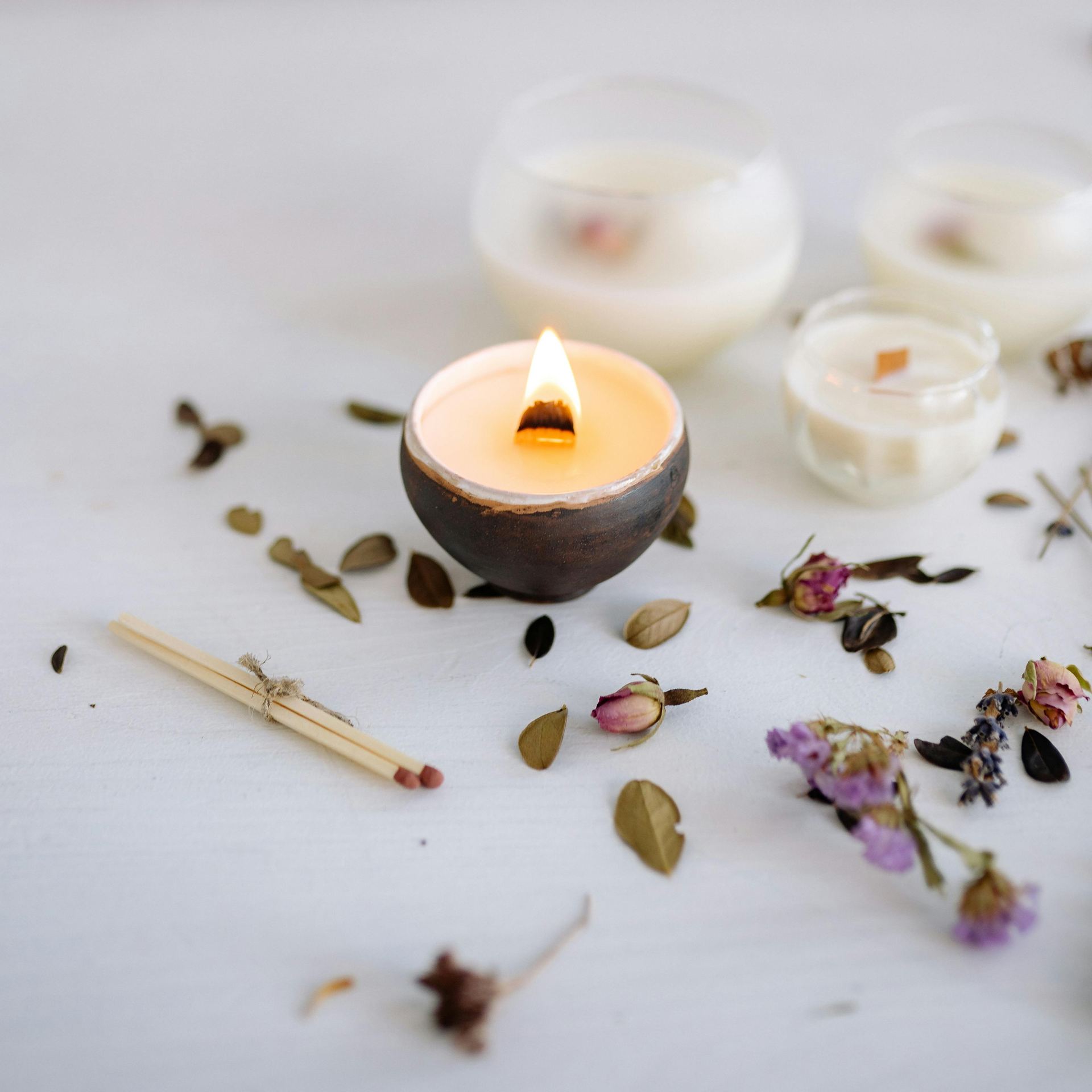 Warm candlelit scene with dried flowers and matches, perfect for relaxation or home decor aesthetics.