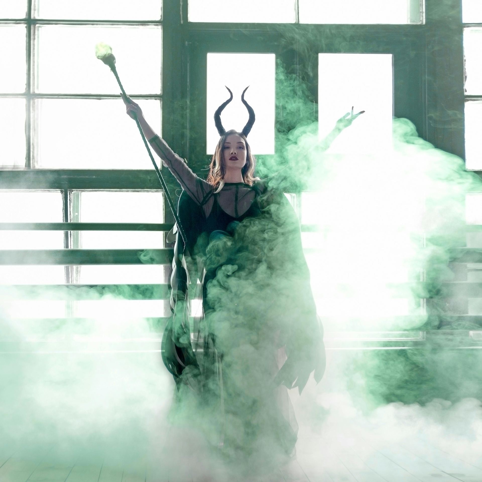A Woman Wearing Black Costume with Horns Surrounded with Smoke