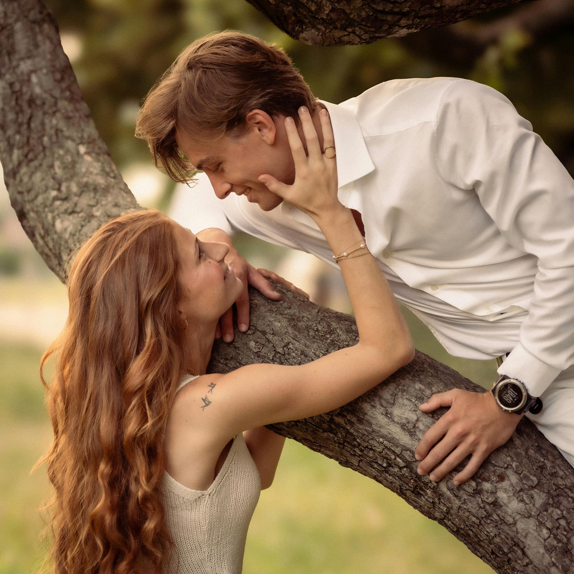 A young couple leaning against a tree
