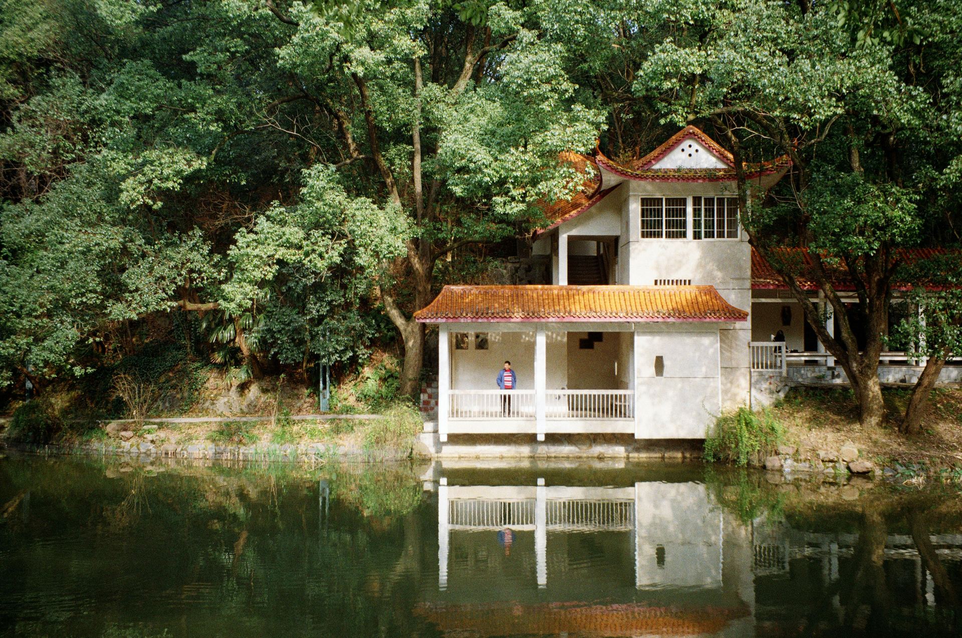 A small house sits on the edge of a lake