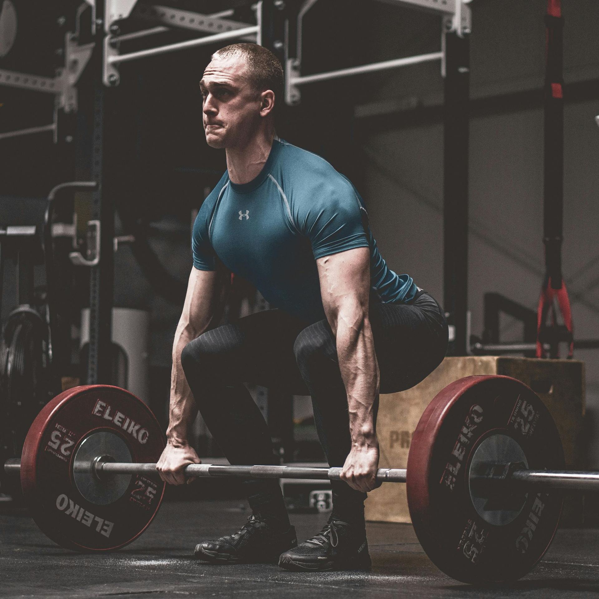 Man in Blue Shirt Lifting a Barbell