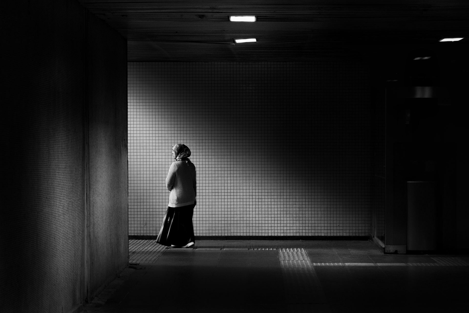 A woman walking down a dark tunnel